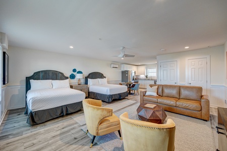 Relax in your spacious suite with two plush beds, a cozy leather sofa, and modern amenities for the perfect getaway.