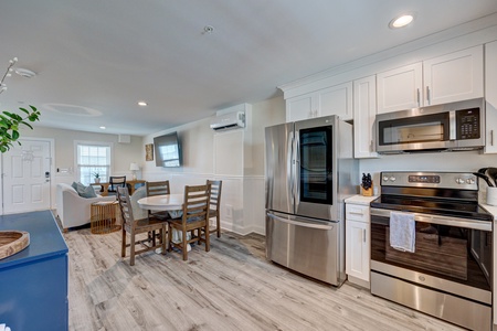 Your bright, modern kitchen flows seamlessly into the dining area, featuring stainless steel appliances and white cabinets for all your culinary adventures.