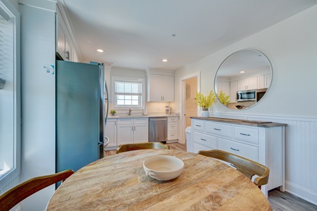 Gather around this beautiful wood dining table in your fully equipped kitchen, complete with modern appliances and coastal charm.