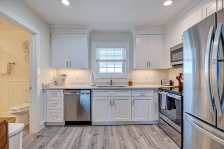 Your bright modern kitchen features stainless steel appliances, white cabinetry, and granite counters—perfect for preparing meals during your stay.