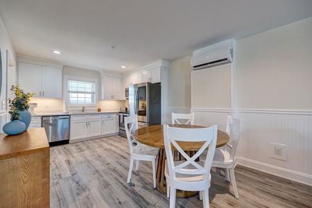 Your bright kitchen features crisp white cabinets, stainless steel appliances, and a cozy dining table where you'll start mornings with coffee.