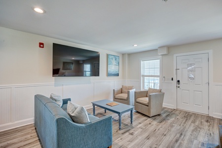 Settle into your bright, coastal-inspired living space with comfortable seating and large TV for relaxing evenings after your adventures.