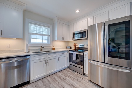 Your bright, fully equipped kitchen features stainless steel appliances and crisp white cabinetry, creating the perfect space for preparing meals during your stay.