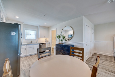 Gather around your spacious dining table in this bright, modern kitchen with gleaming appliances and coastal charm.