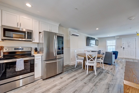 Your spacious kitchen features stainless steel appliances, white cabinetry, and an open layout flowing into your cozy dining and living areas.