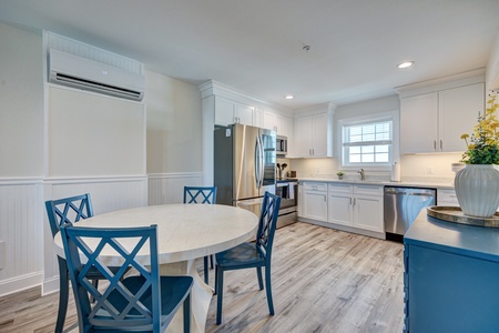 Step into your fully equipped kitchen featuring stainless steel appliances, crisp white cabinets, and a cheerful dining nook where you'll start each morning.
