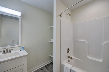 Fresh and bright bathroom features your own shower-tub combo with built-in storage shelving for all your essentials.