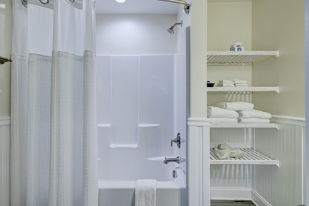 Refresh in your private bathroom with a spacious tub-shower combo and built-in shelving stocked with fluffy towels.