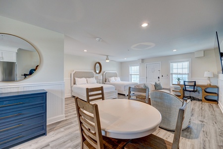 Your spacious room combines comfort and style with two cozy beds, a dining table for meals, and elegant coastal touches throughout.