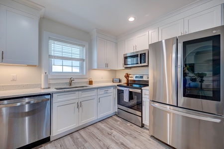 Your fully equipped kitchen features stainless steel appliances and bright white cabinets, perfect for preparing meals during your stay.