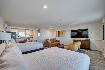 Unwind in your spacious suite with two queen beds, cozy seating area, and full kitchen - perfect for your group getaway.