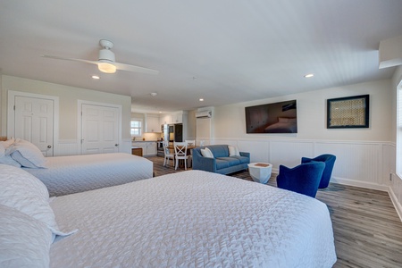 Your spacious suite combines comfort with convenience, featuring two queen beds, a cozy seating area, and open kitchen perfect for your beach getaway.