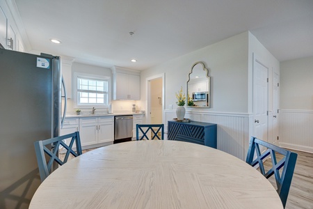 Your spacious kitchen awaits with bright white cabinetry and charming blue accents creating a coastal-inspired gathering space for memorable meals.