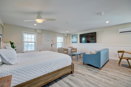 Unwind in your spacious suite featuring a plush bed, cozy seating area, and modern amenities for the perfect coastal retreat.