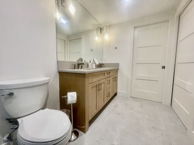 An oversized single vanity is in the guest bathroom.