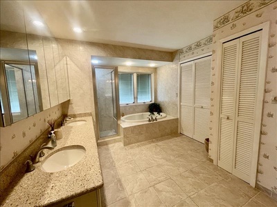 The massive primary bath with soaking tub, shower, walk-in closet, water closet and dual vanities.