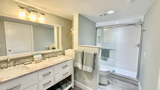 Primary bathroom with dual vanities and custom shower.