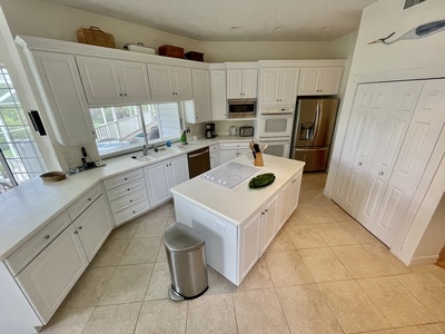 Fully-equipped, spacious kitchen overlooks the preserve and pool.