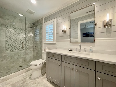 The en-suite bath with oversized vanity, custom tile shower.