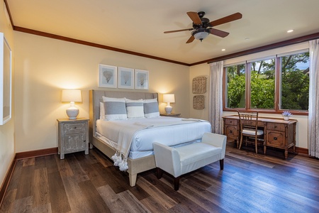 Elegant primary bedroom with king bed and serene garden views