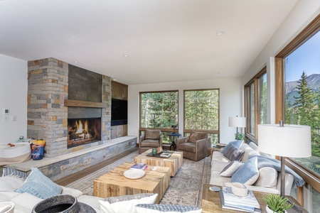 Huge open air living room with large gas fireplace, smart TV and views of surrounding aspen groves