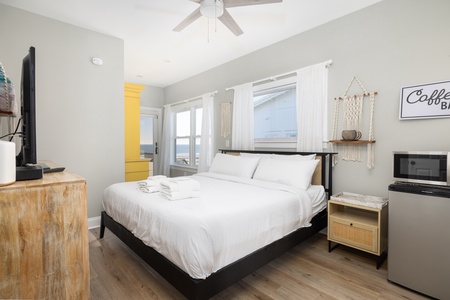 Drift off in your cozy bedroom with crisp linens, ceiling fan comfort, and warm natural light streaming through curtained windows.