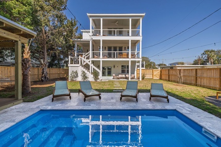 Your private pool awaits with comfortable loungers perfectly positioned for soaking up sunshine in this peaceful backyard retreat.