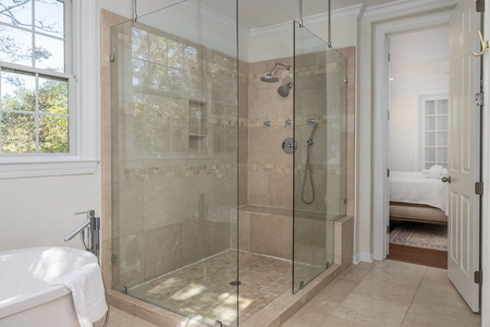 Large en suite primary bathroom with jack and jill sinks and a tub to unwind in.