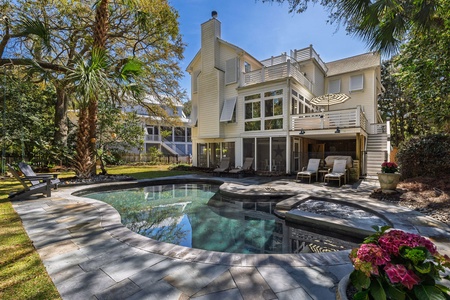 Luxurious home featuring pool, spa, and lush tropical landscaping in an upscale neighborhood setting.
