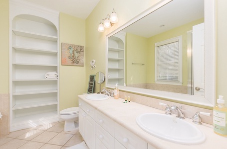 Refresh in your spacious bathroom featuring dual sinks, built-in storage, and warm coastal touches that make morning routines feel luxurious.