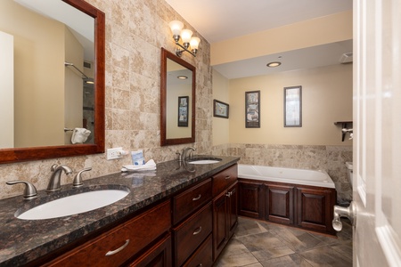 Your elegant primary bathroom includes a deep jacuzzi tub and glass walk-in shower