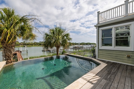 Dive into your private oasis with this shimmering pool overlooking tranquil waterfront views, palm-shaded decks, and marina docks—your perfect escape awaits.