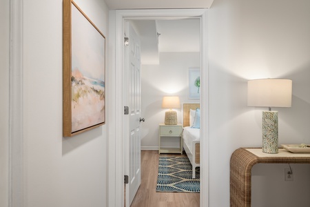 Step into your serene bedroom sanctuary, where coastal artwork and soft lighting create the perfect retreat for peaceful nights.