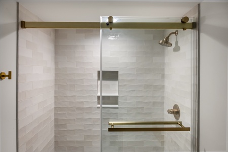 Step into your spa-like shower with elegant subway tiles, rainfall showerhead, and brass fixtures that create a luxurious daily ritual.