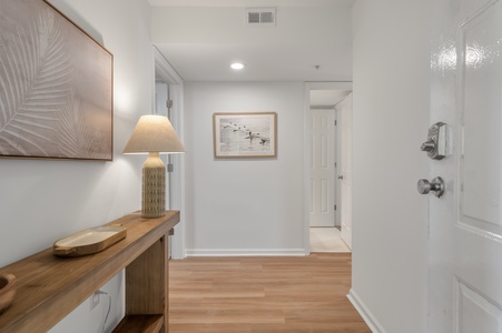 Step into your bright, welcoming entryway where warm wood tones and coastal art create an instantly relaxing atmosphere for your getaway.