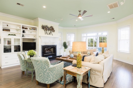 Sink into plush seating by your cozy fireplace, where coastal charm meets comfort in this inviting living space perfect for relaxing evenings.
