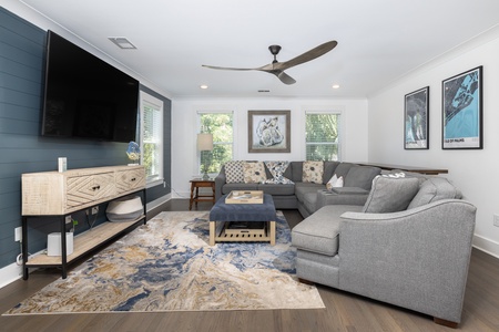 A comfortable living space with large television sits just beyond the dining room