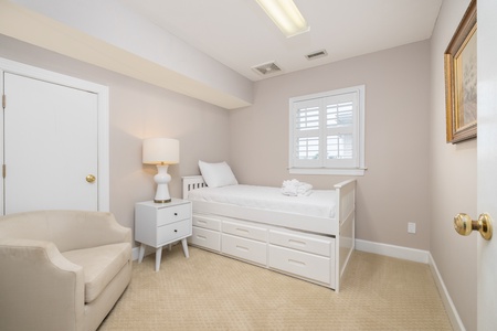 Unwind in this serene bedroom with a daybed and soft textures. Natural light filters through plantation shutters, creating a calming space where you can read, rest, or simply escape the day.