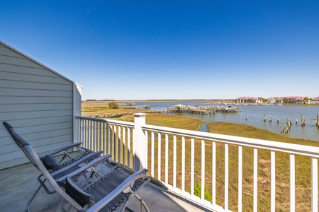 Enjoy expansive waterfront views over the marsh and marina from your primary bedroom balcony
