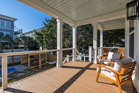 Unwind on your private covered balcony with stylish teak seating and serene pool views below.