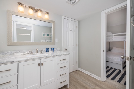 The Jack and Jill bathroom features a large mirror and tub-shower combo