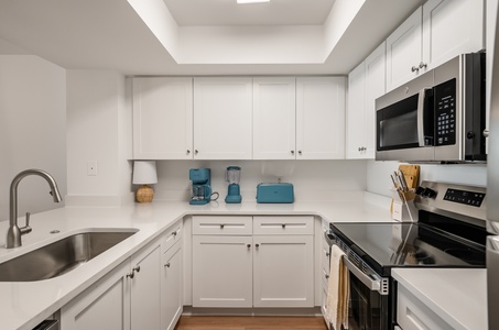 Your bright, fully-equipped kitchen features modern appliances and crisp white cabinetry, perfect for preparing meals during your stay.