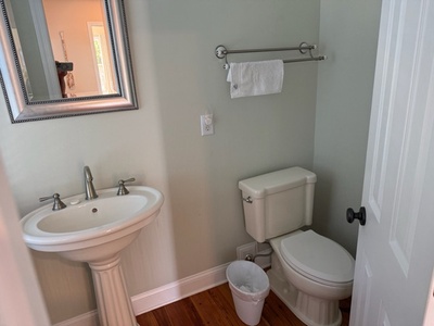 Your private half-bath features elegant fixtures and warm hardwood floors, creating a comfortable space for you and your guests.