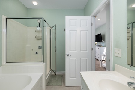 The primary en suite bathroom features a large jacuzzi tub and glass shower