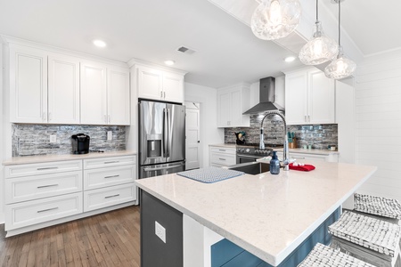 Your fully equipped kitchen comes with a professional-grade gas range, stylish backsplash, and elegant lighting