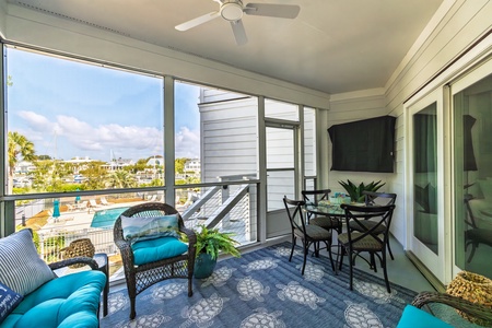 Your screened-in porch offers comfortable seating and dining with views of the marina and pool area below
