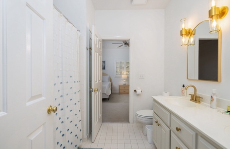 Shared Jack and Jill bathroom with tub-shower combo and convenient access from adjoining bedrooms