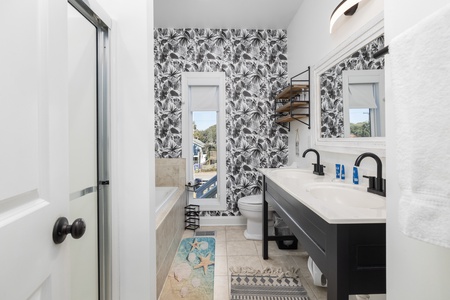 You'll love this en suite bathroom with tropical wallpaper and a large soaking tub