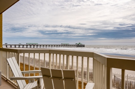 Oceanfront balcony with stunning pier views and comfortable seating for your perfect beach getaway moments.