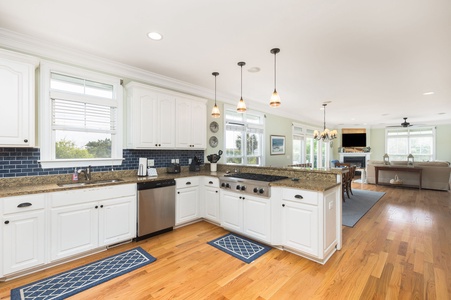 White cabinetry, stainless steel appliances, and modern pendant lighting create an inviting space to cook fresh seafood.